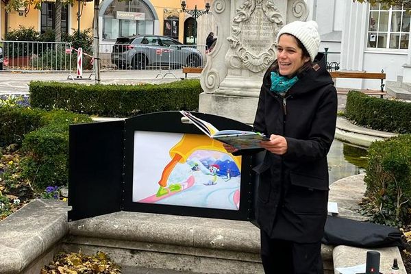 Frau liest aus Buch vor