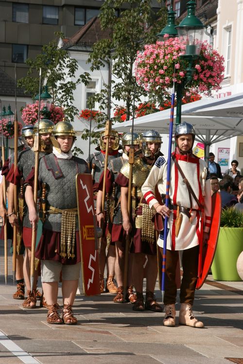 Römische Formation auf dem Hauptplatz: Historisch gekleidete Legionäre spazieren in Formation.