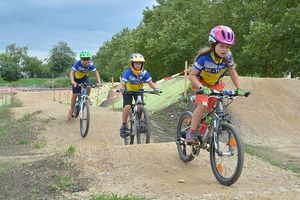 Kinder mit Fahrrädern auf der BMX-Bahn