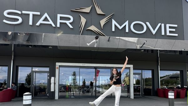 Frau vor Star Movie mit Getränk in der Hand