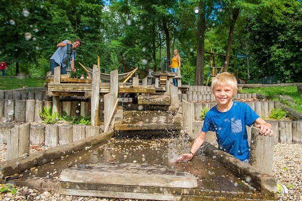 Kind spielt mit Wasser am Spielplatz der GARTEN TULLN