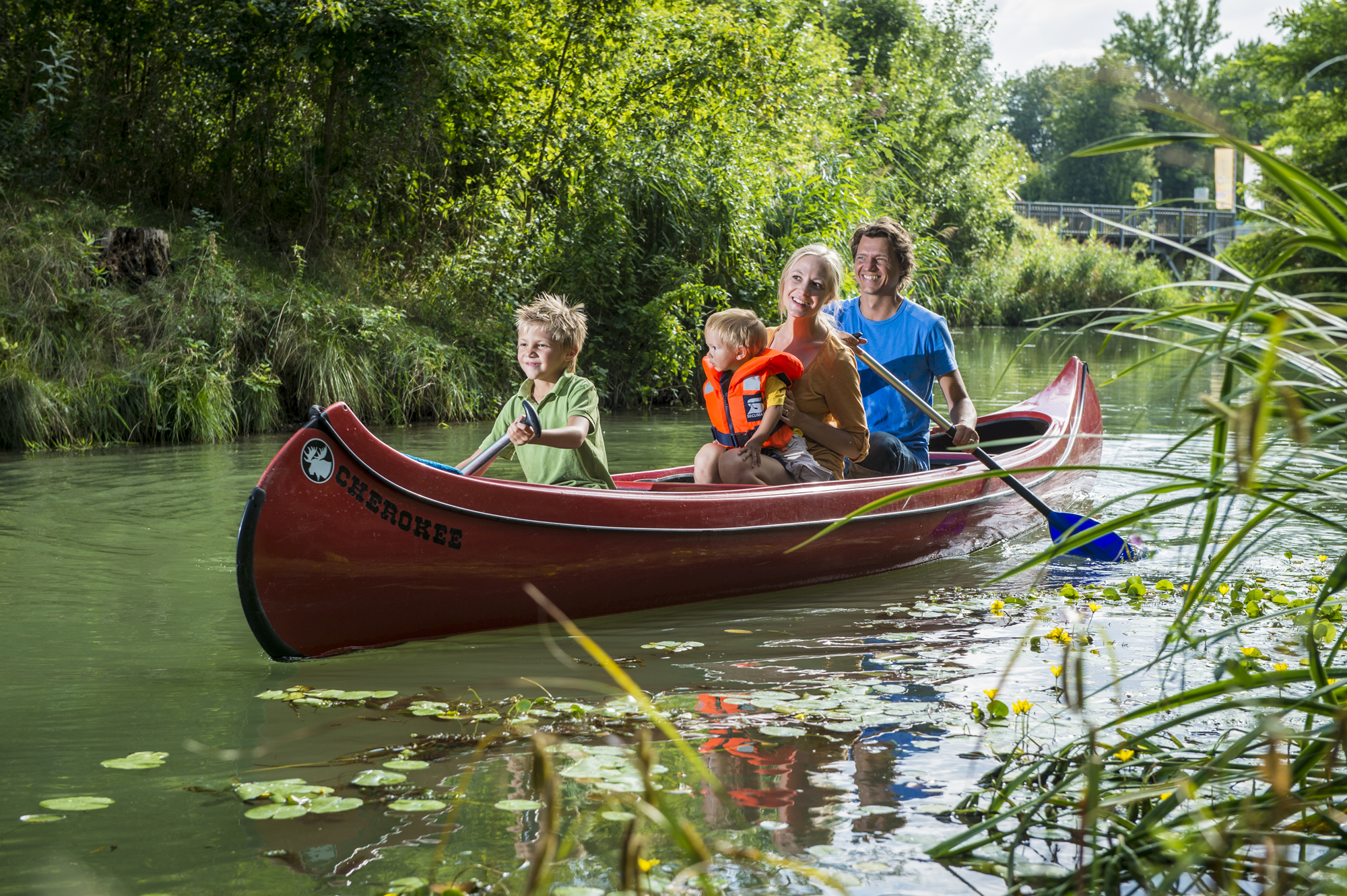 Familie mit fährt mit Kanu im Wasserpark