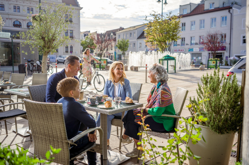 Familie sitzt im Schanigarten am Hauptplatz 