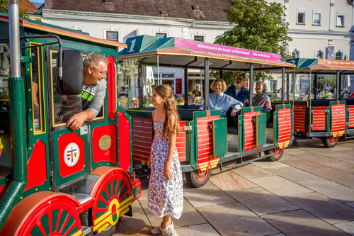 Mädchen steht vor Tulli und Fahrgäset sitzen inTulli 