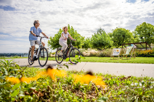 Paar fährt mit dem Rad an der Donaulände